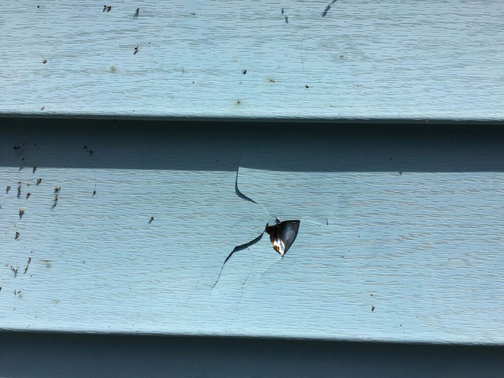 Damaged siding with a noticeable crack.