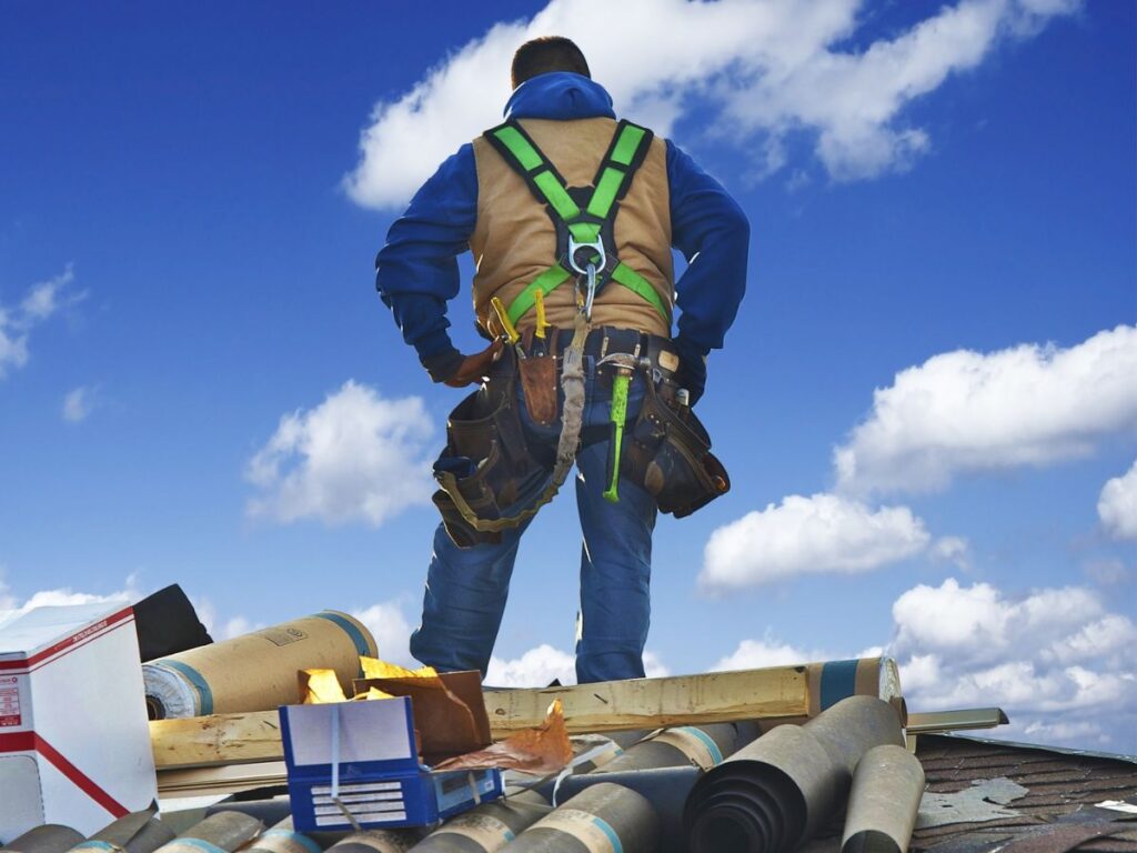 A man with a complete safety gear standing on the roof.