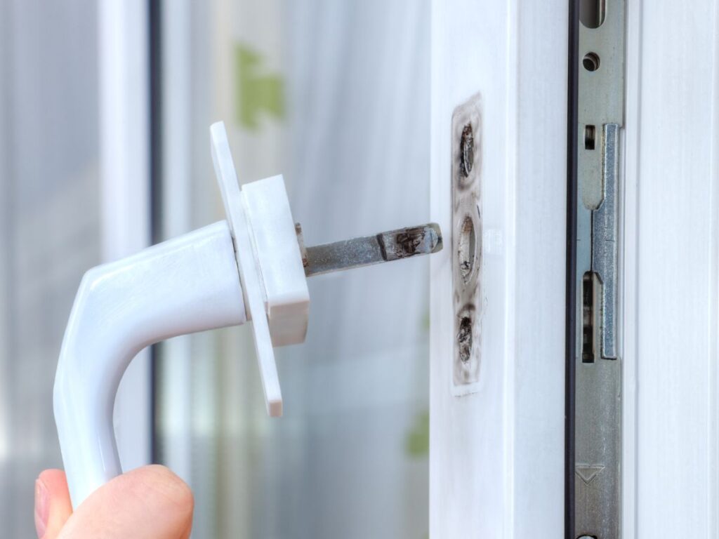 Close-up of a broken window handle being replaced.