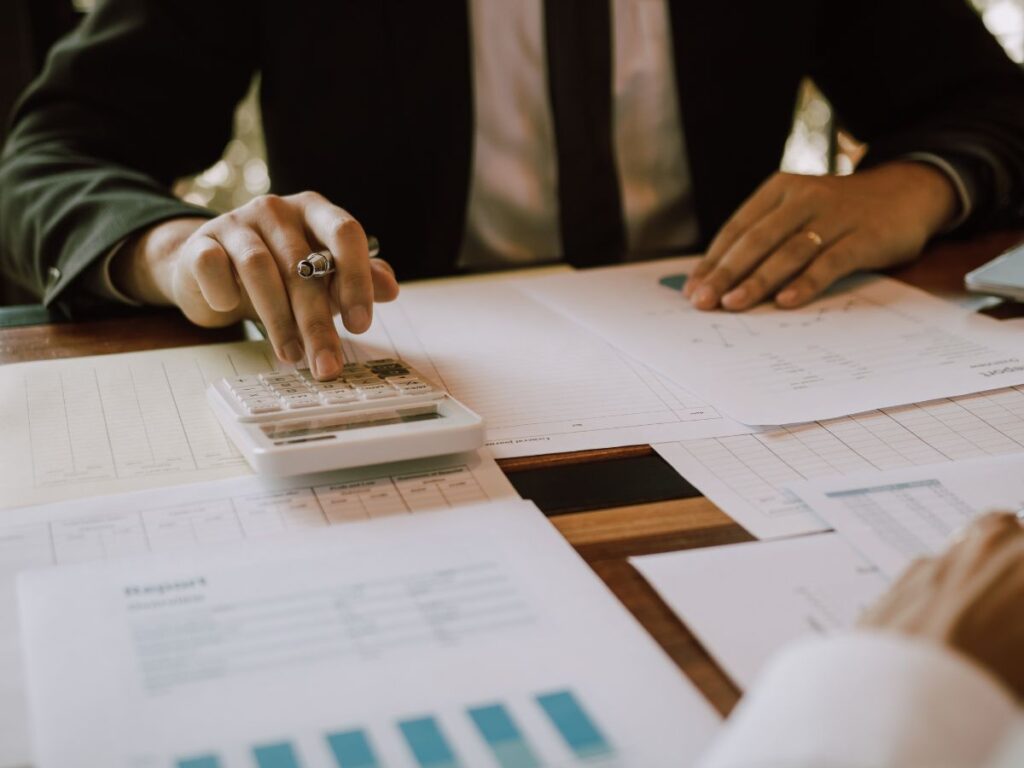 A man in a suit calculating using a calculator.