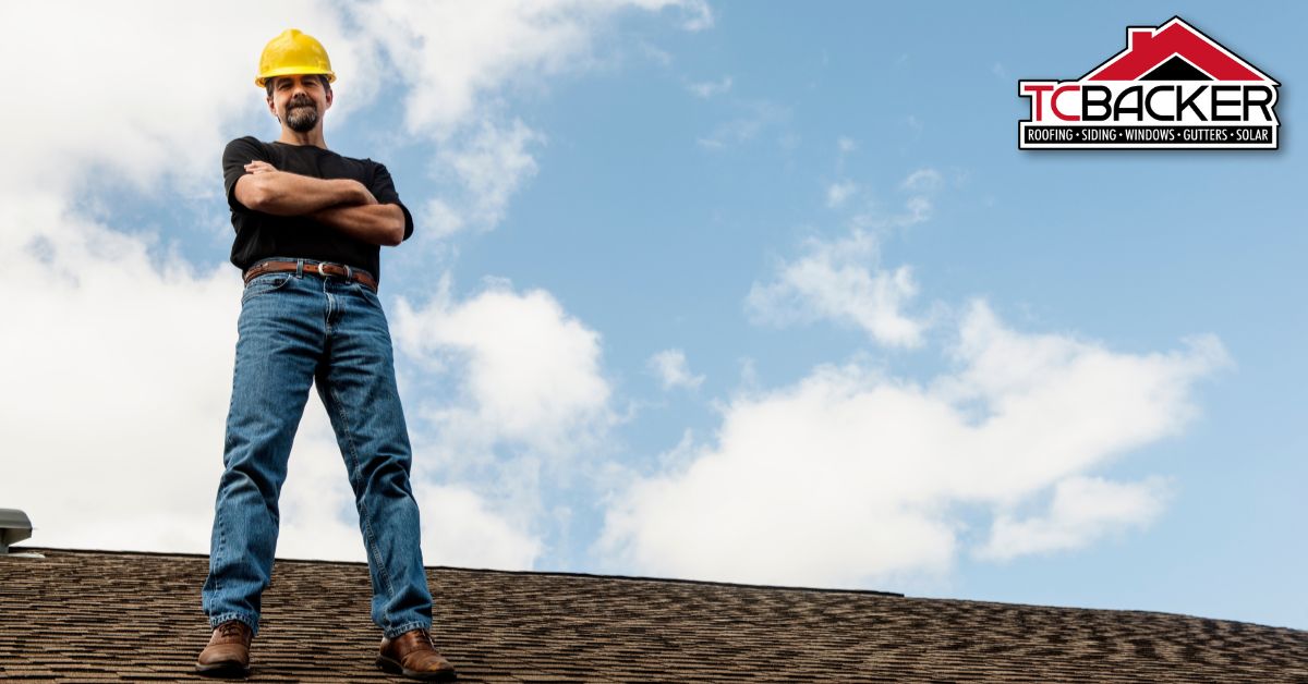 A man standing on a roof with cross hands.