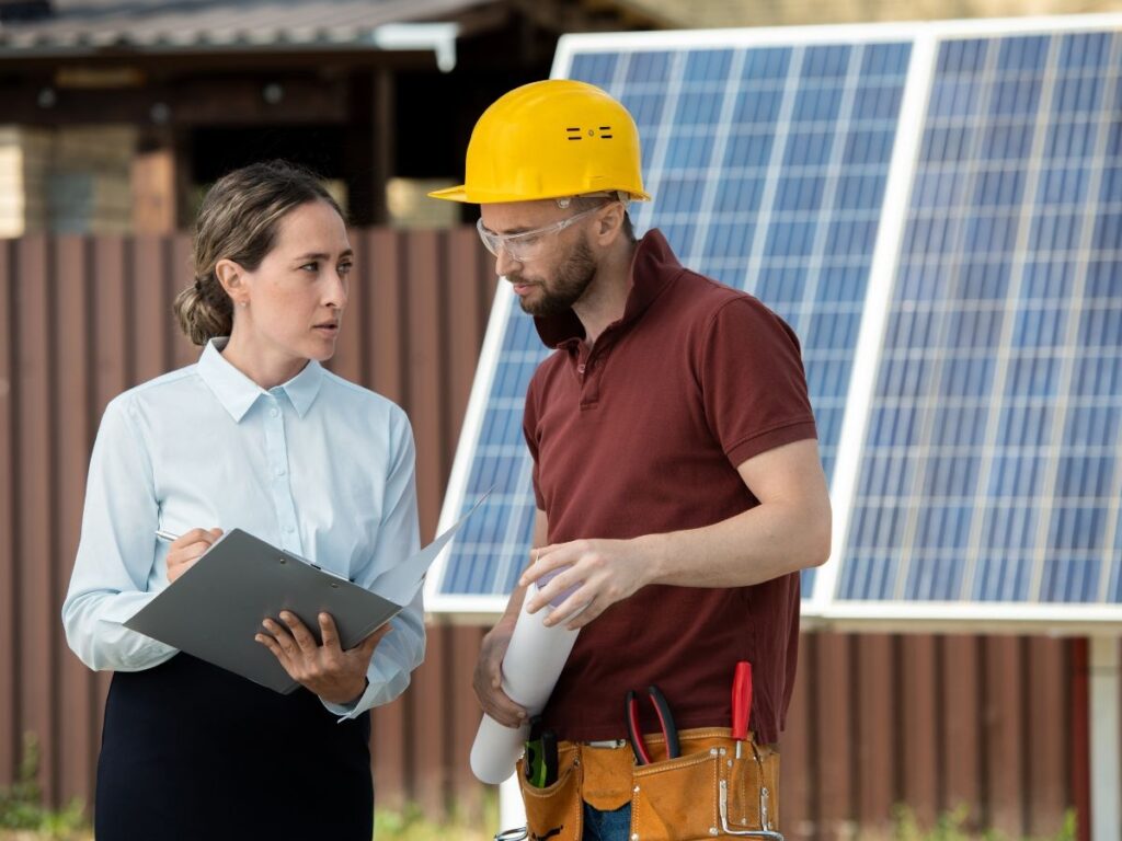 A woman while holding a clipboard discussing the plans on the contractor.