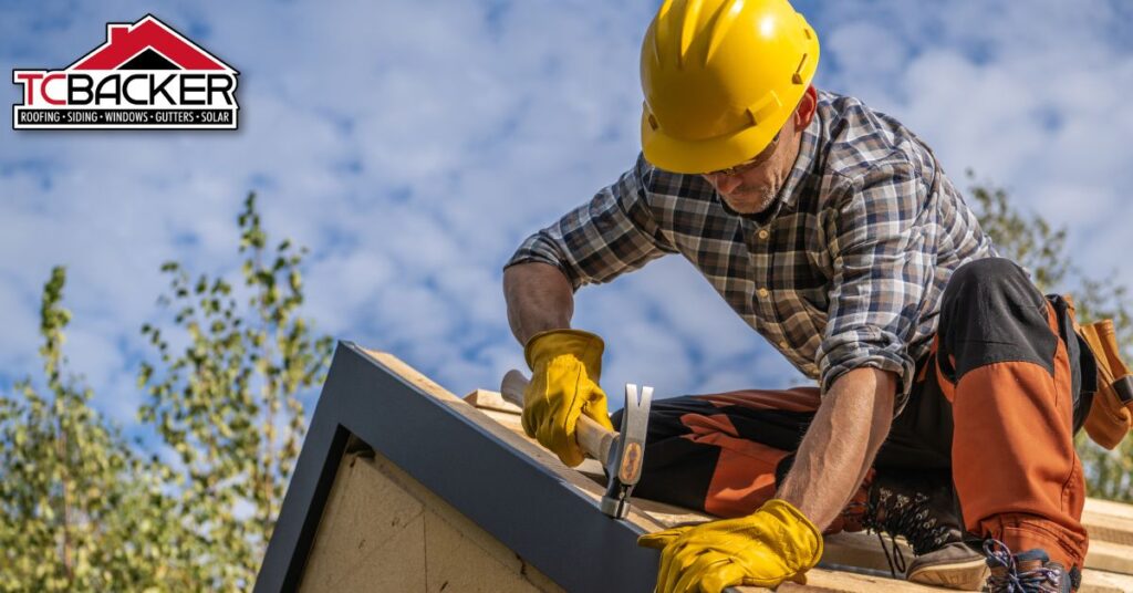 Worker hammering a roof edge with a yellow helmet.